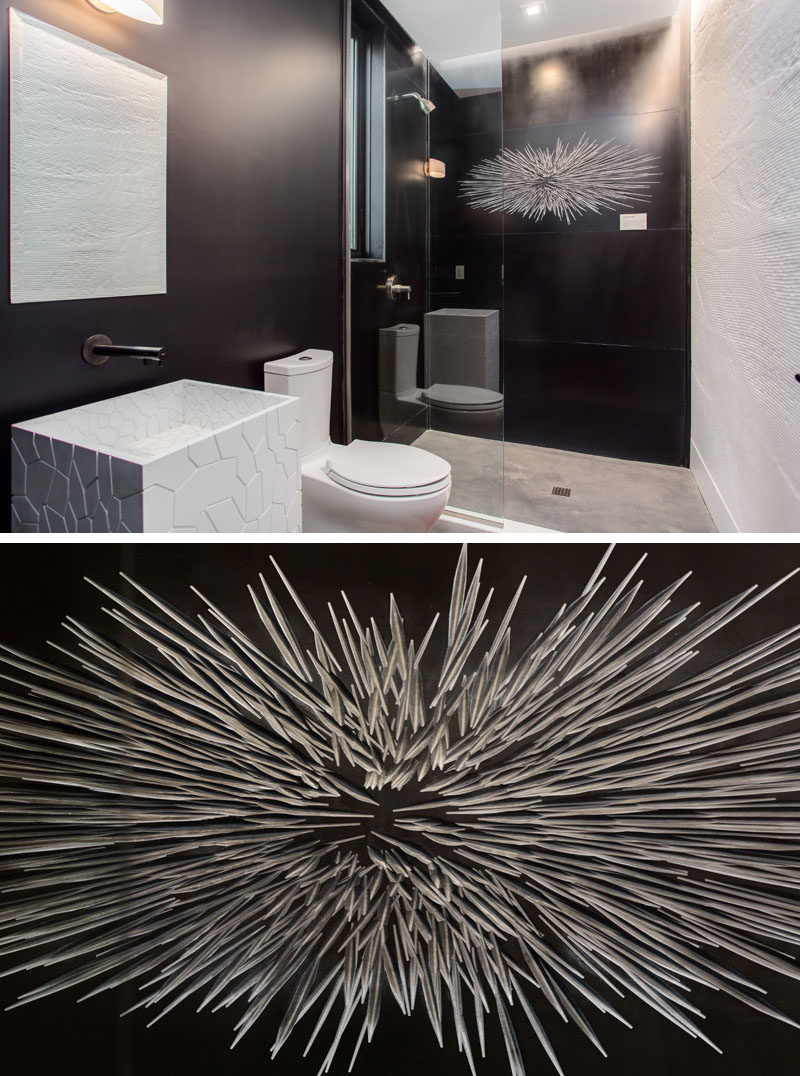 This modern bathroom has artistic tile pattern covering the wall in the shower.