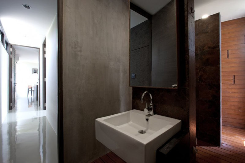Concrete has been combined with wood and stone for an earthy look in this bathroom.