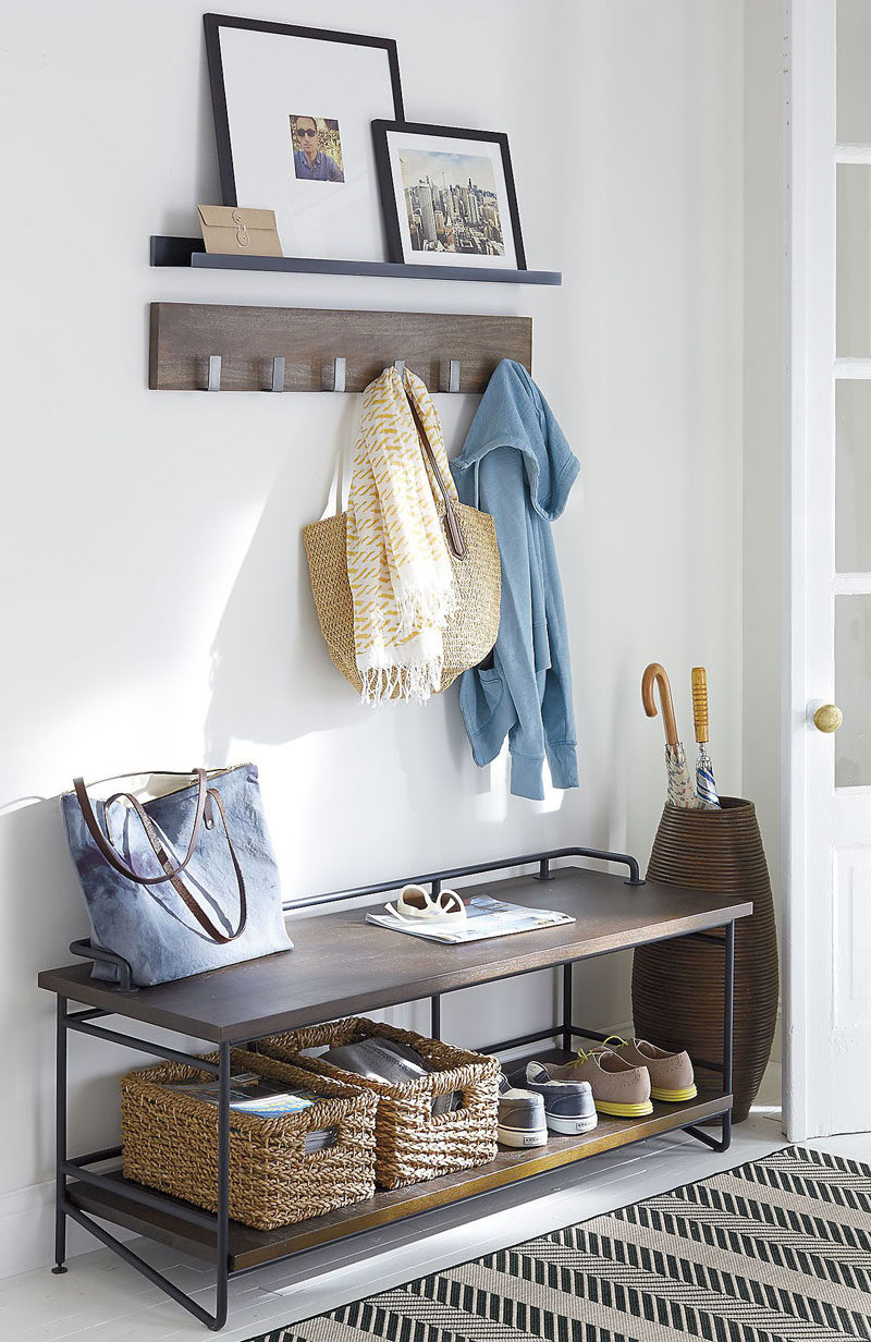 Entryway Design Ideas - 3 Different Styles Of Entryway Benches // The dark wood and metal piping on this entryway bench contrasts the white interior but matches the shelf and coat hangers above it to make the spot feel styled and put together.