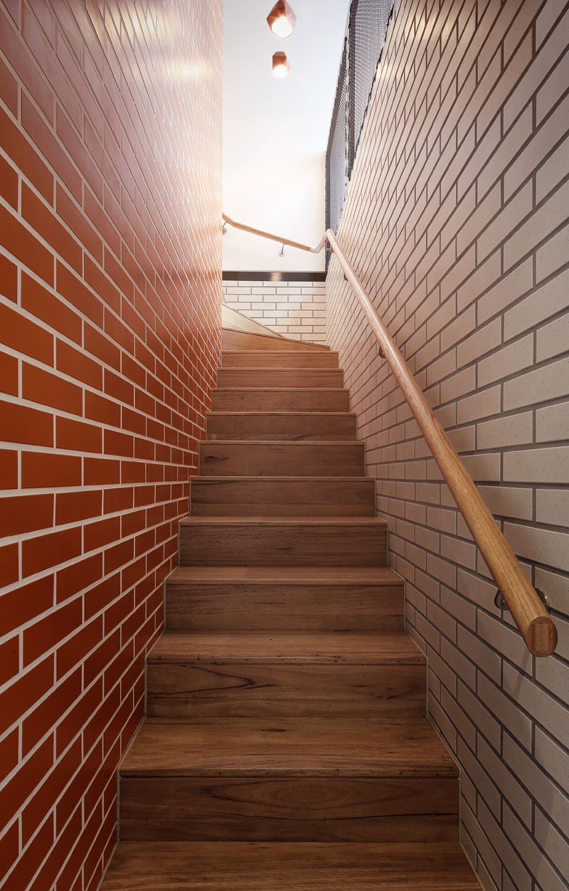 Different colored bricks line the staircase leading to the upper floor of this home.