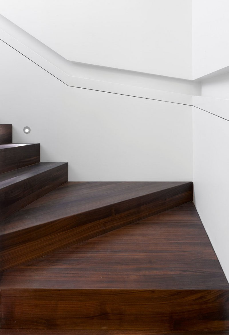 Stair Design Idea - 9 Examples Of Built-In Handrails // This white wall that wraps around the stairs has a section cut-out of it to house the handrail. 