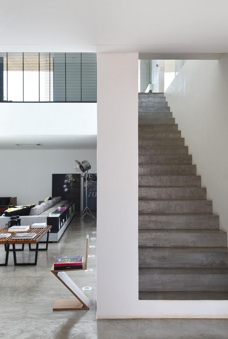 Concrete stairs are tucked behind the living area in this house.