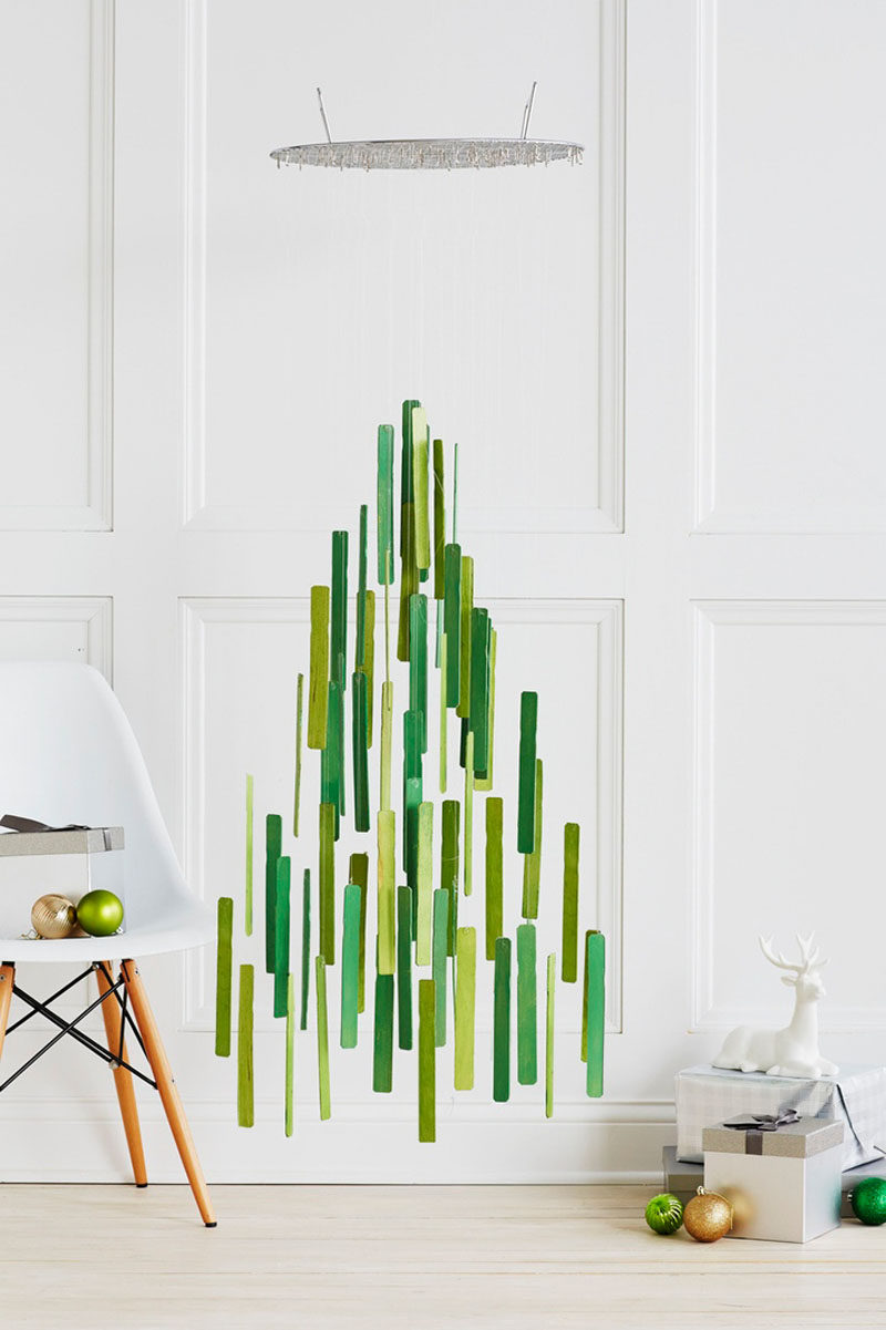 Christmas Decor Ideas - 14 DIY Alternative Modern Christmas Trees // Paint stir sticks have been painted and suspended from a steamer rack to create a floating Christmas tree alternative that has lots of room underneath it - perfect for stacking up the presents.