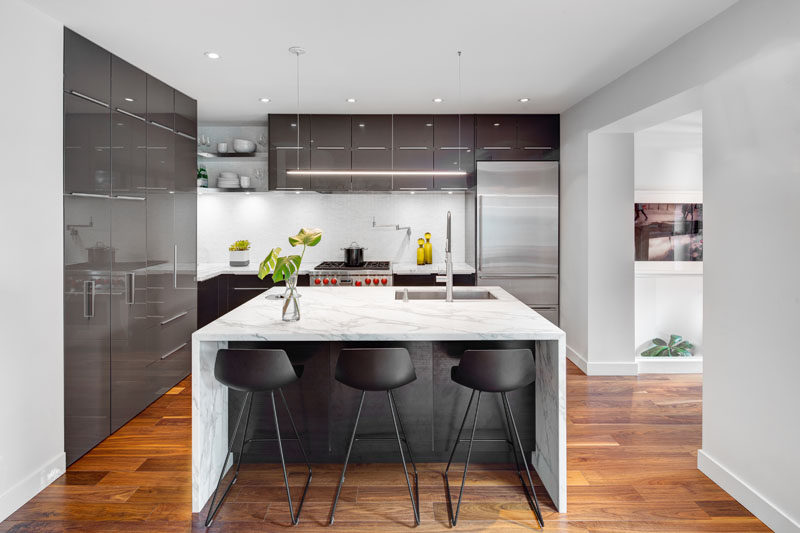 A central island, open shelves in the corner and sleek cabinetry make up this contemporary kitchen.