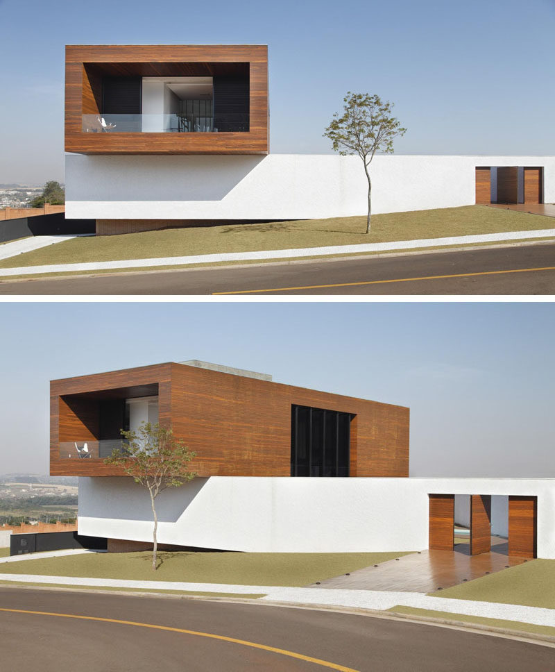 This modern home in Brazil has a Cumaru wood clad concrete box that extends out over the long white exterior wall.