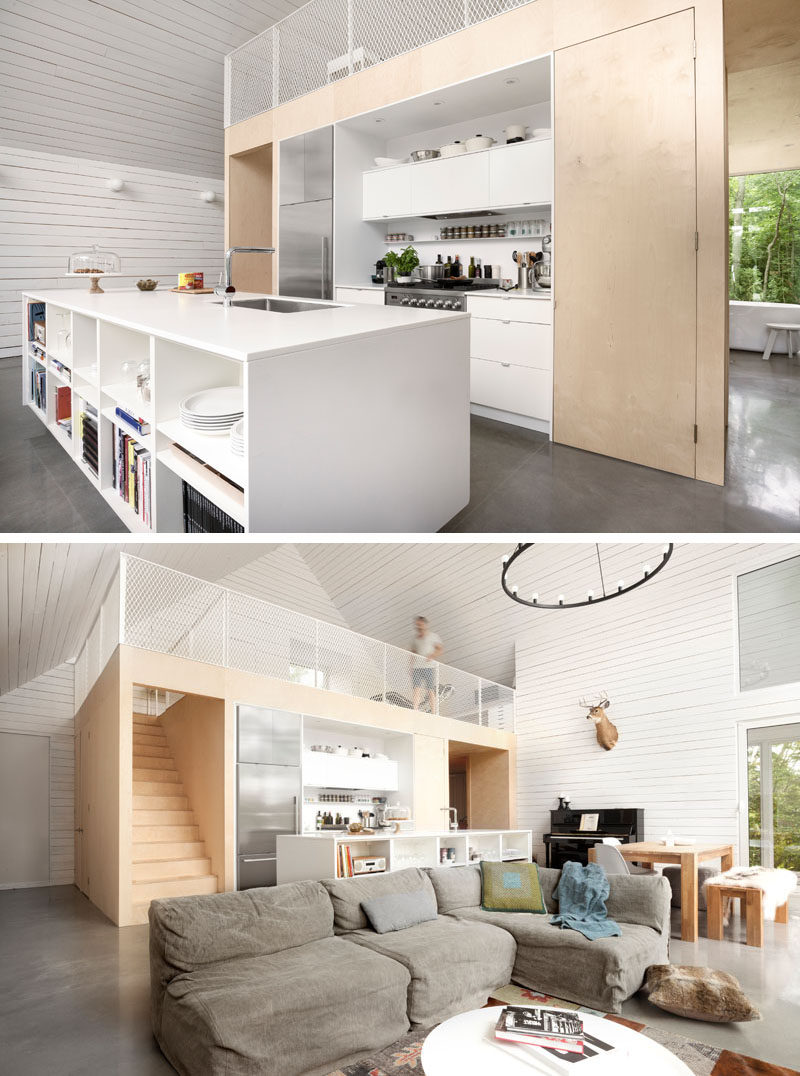 In this chalet, the kitchen has a large white island with shelving on one side, ideal for storing books and games. Above the kitchen is a loft with additional living space.