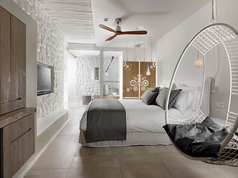 This boutique hotel room in Mykonos features decorative artistic wooden panels hanging from the ceiling.