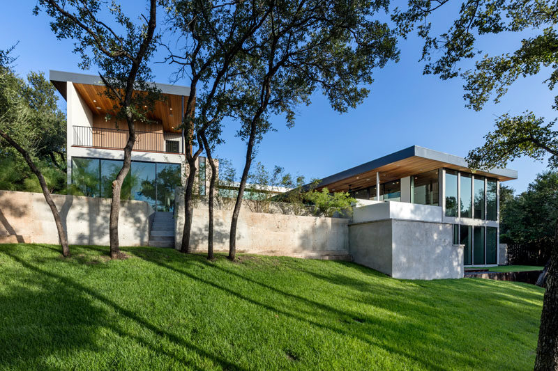 This house in Texas has steps that lead down to a sloped yard. A retaining wall makes it possible to have a swimming pool at the same level as the living spaces.