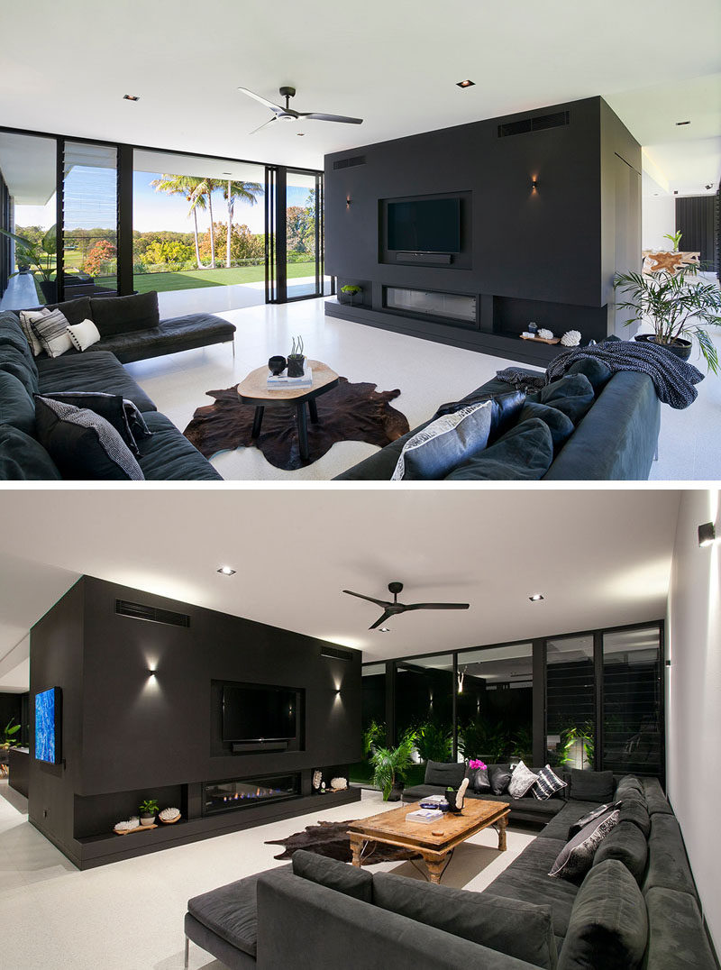 This modern living room is open to the backyard of this home. A large sofa focused on the tv and fireplace makes it the ideal place to watch movies.
