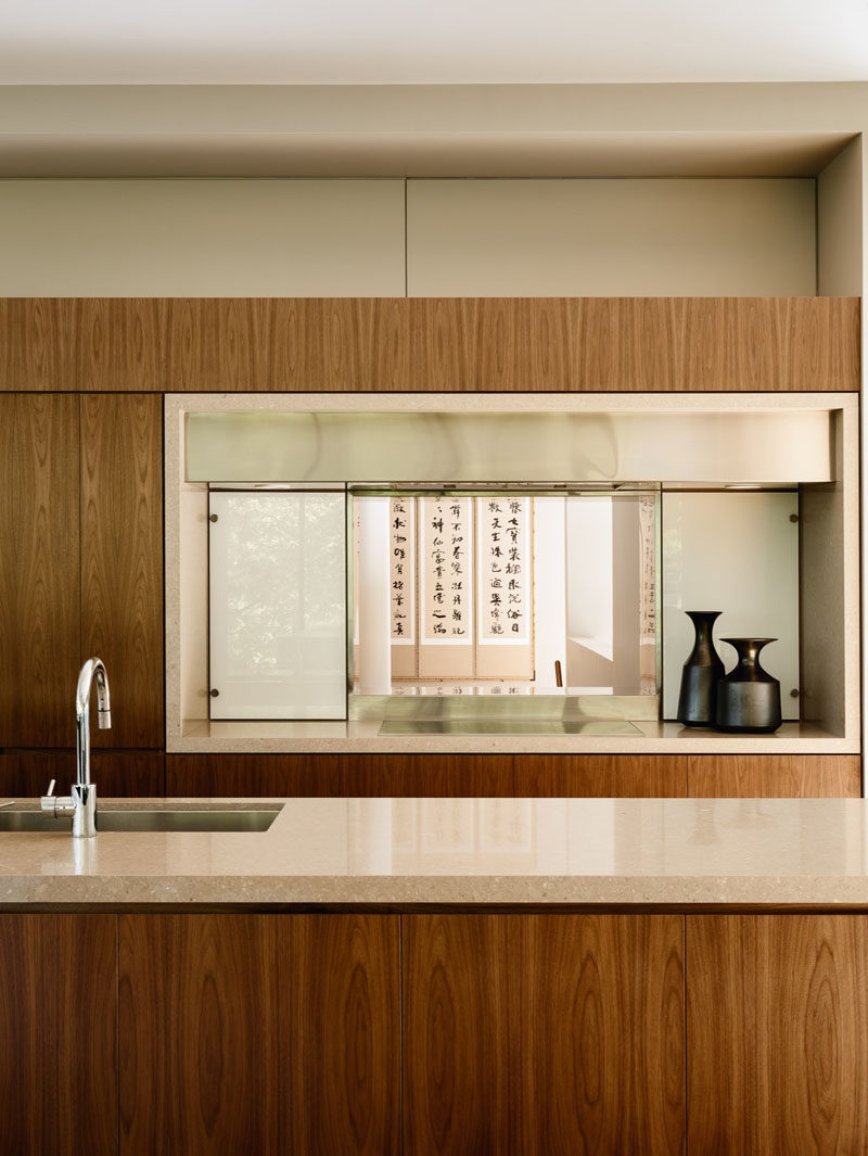 Wooden cabinetry has been paired with light cream colored stone to create a contemporary kitchen look.