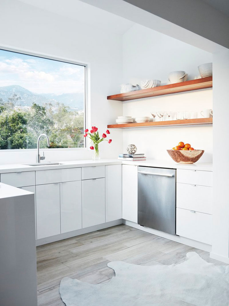 In this kitchen, a large picture window perfectly frames the view of the mountains and open wood shelving lets you display your favorite serving items.