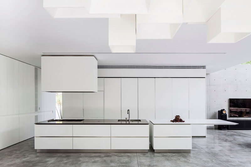 Kitchen Design Ideas - White, Modern and Minimalist Cabinets // The heavy use of white and concrete give this kitchen a modern and futuristic look.