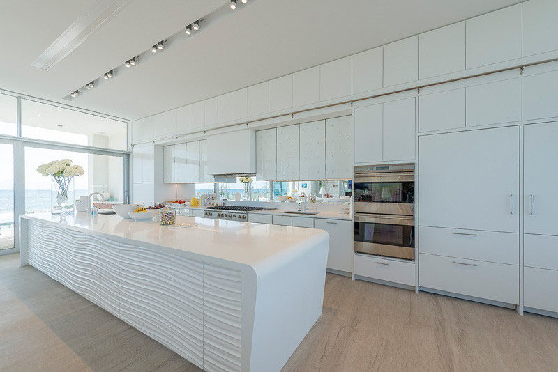 Kitchen Design Ideas - White, Modern and Minimalist Cabinets // White cabinetry, white countertops, and an all white island give this kitchen a clean look and brightens up the rest of the living space.