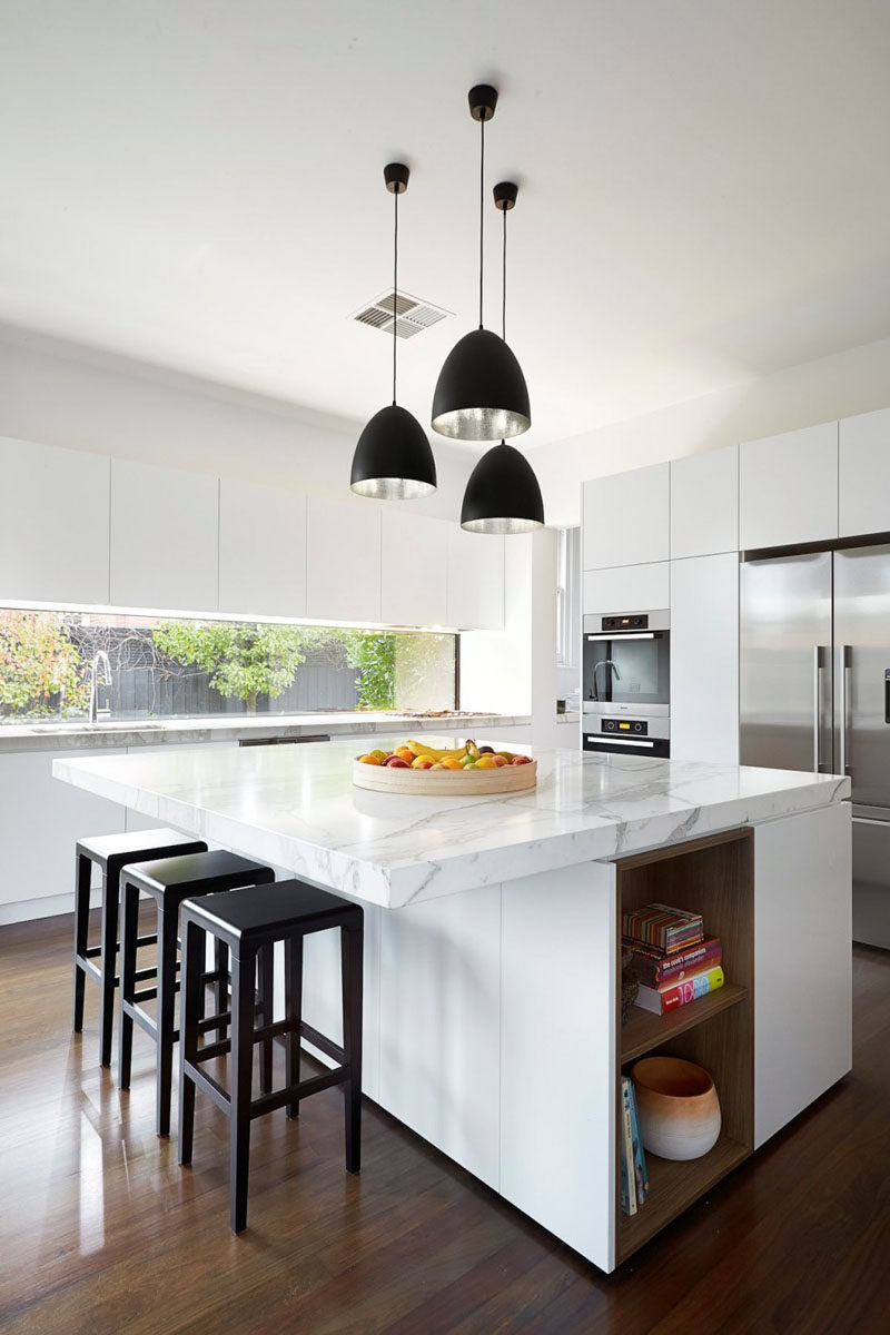 Kitchen Design Ideas - White, Modern and Minimalist Cabinets // The white cabinets, stainless steel appliances, and marble countertops give this kitchen a super modern feel, while the wood floors keep it feeling warm and homey.