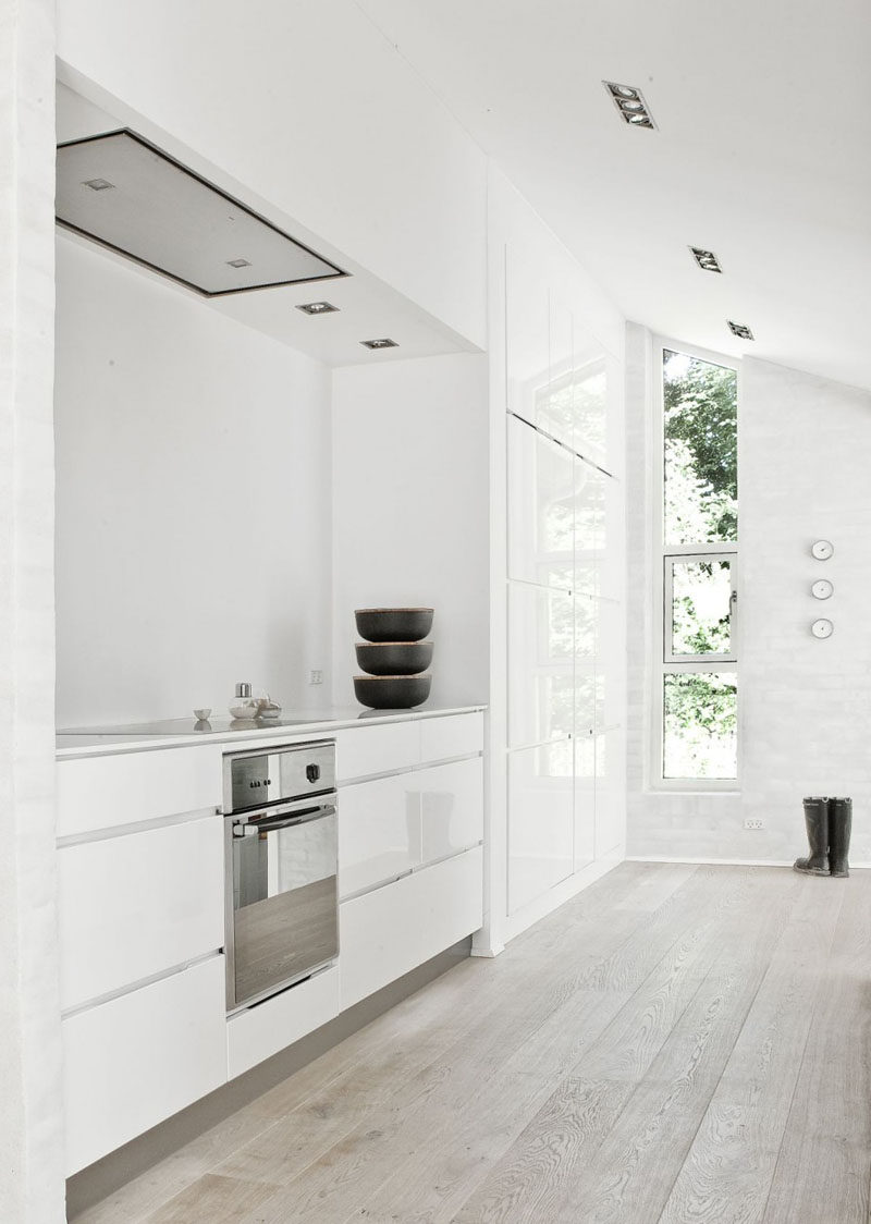 Kitchen Design Ideas - White, Modern and Minimalist Cabinets // The white cabinetry of this kitchen and the light wood floor give the space an extremely bright look that’s amplified by the natural light coming through the windows.