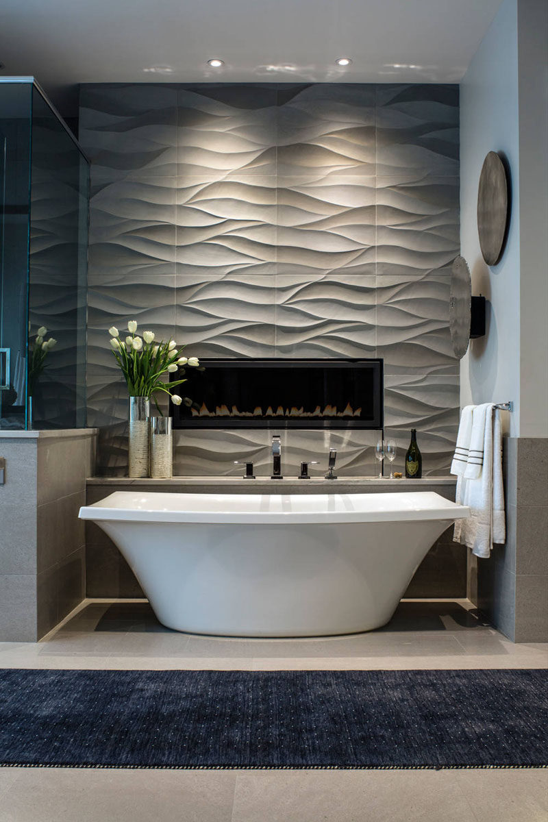 Bathroom Tile Ideas - Install 3D Tiles To Add Texture To Your Bathroom // Wavy tiles behind the bathtub and surrounding the built in fireplace create a feature wall that can also double as art.