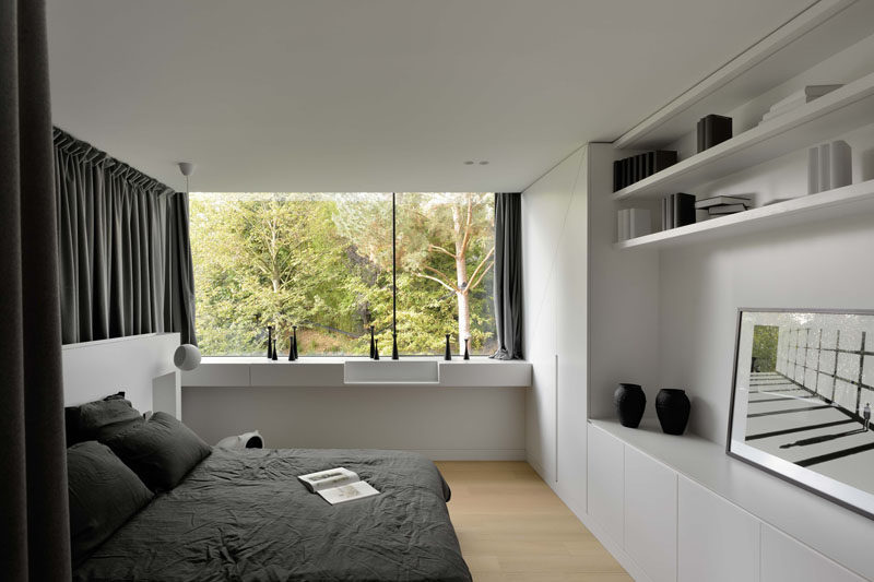 In this bedroom there's a wall covered in built-in cabinetry and open shelving.