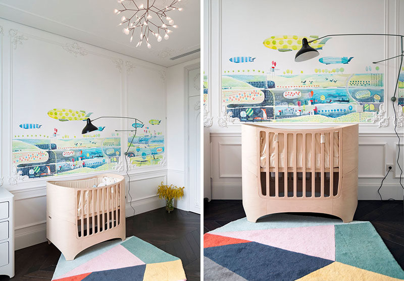 In this nursery they combine old with new. Colorful artwork has been added to the walls and a geometric rug adds a soft surface for the child to play on, white more traditional elements have been added to the walls.