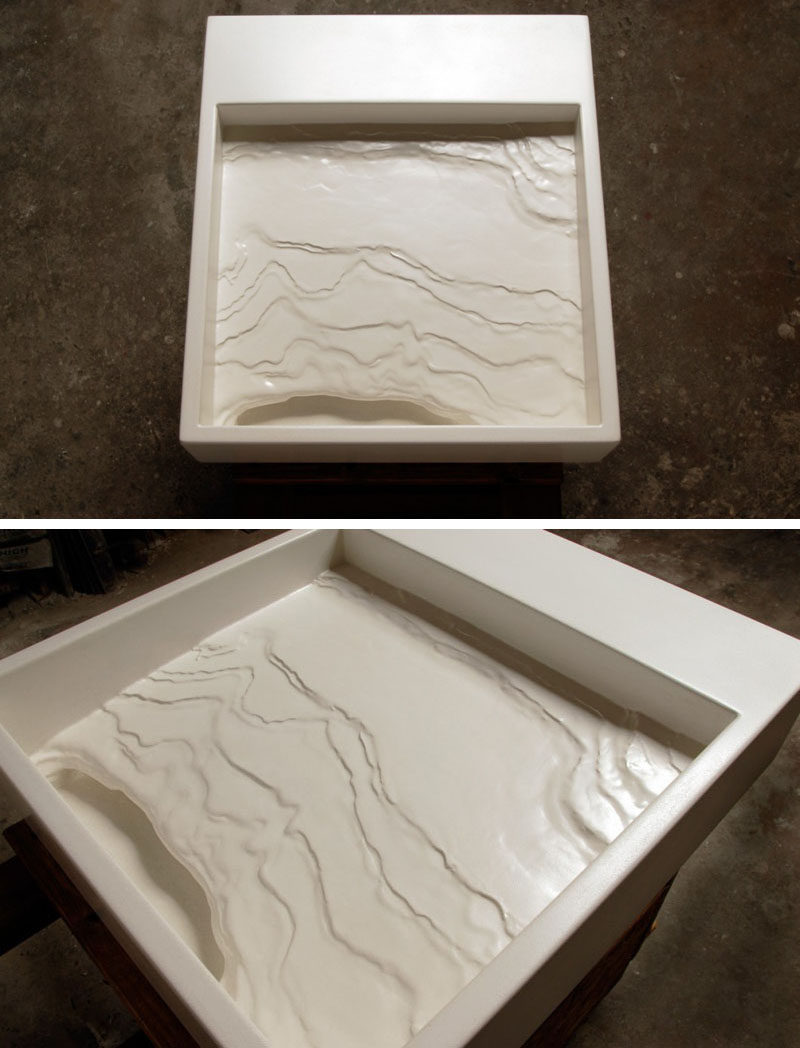 11 Creative Concrete Countertop Designs To Inspire You // This sink resembles an eroding shoreline that tilts down and sends water into a cave-like structure that then sends it down the hidden drain.