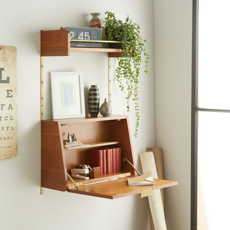 16 Wall Desk Ideas That Are Great For Small Spaces // The door of this shelving unit opens up to become the perfect writing surface that can also hide things when you close it up.