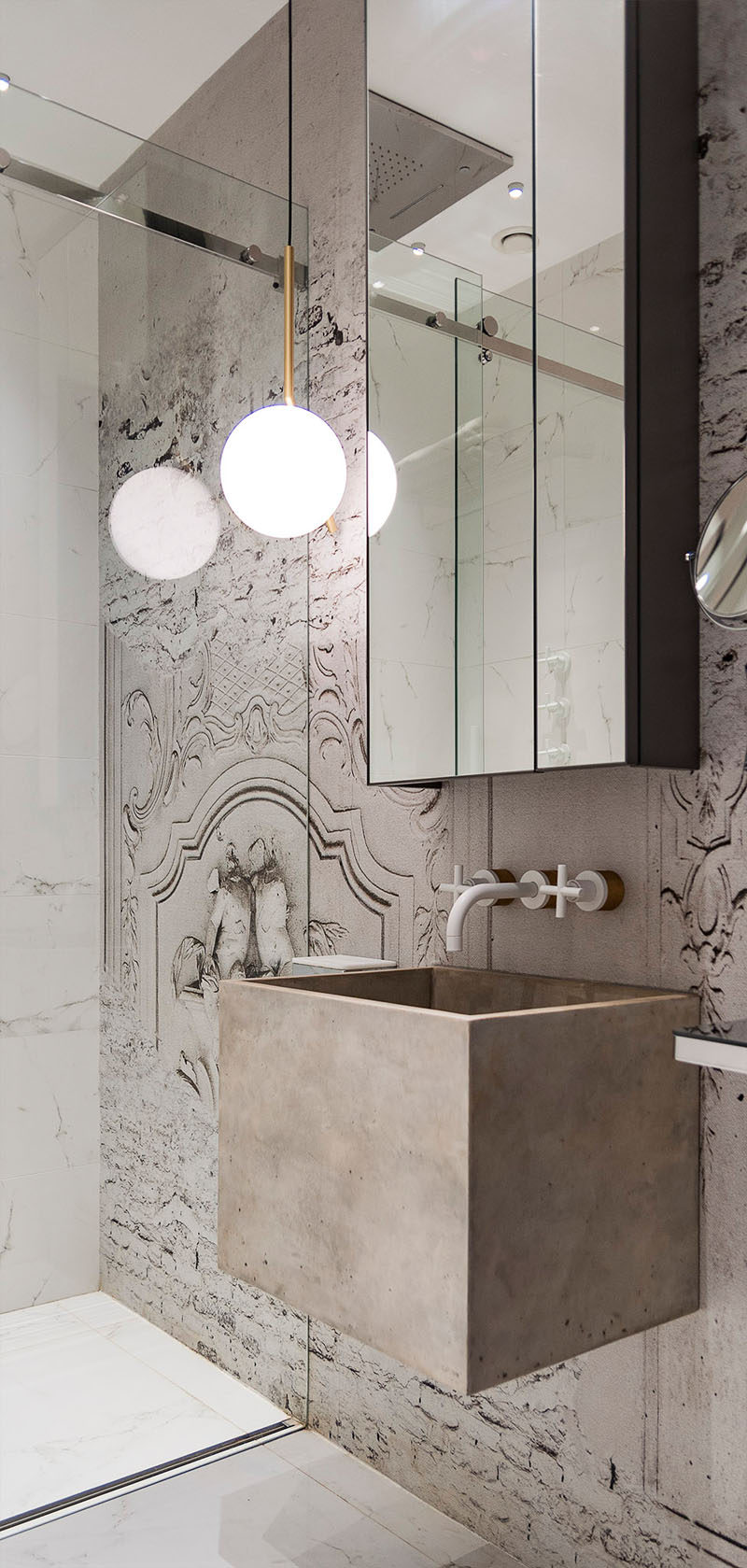 In this bathroom, a deep concrete sink appears to float and a glass shower door allows the mural to carry on uninterrupted into the shower.