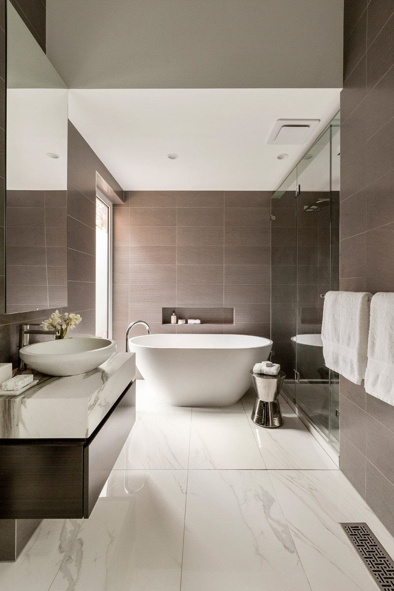 Bathroom Tile Ideas - Use Large Tiles On The Floor And Walls // The large tiles featured on the walls of this bathroom bring out the darker flecks found in the tiles used for the floors. 