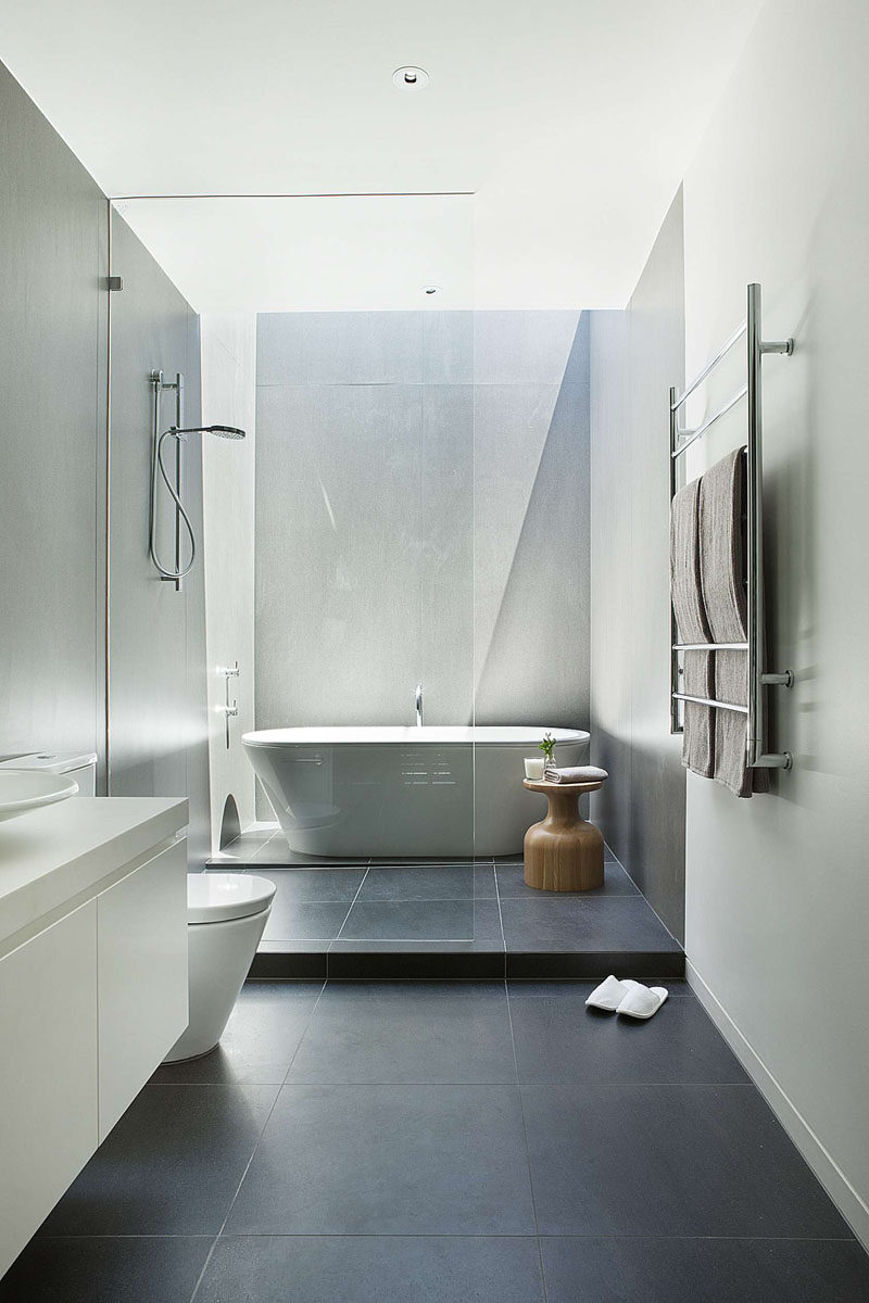 Bathroom Tile Ideas - Use Large Tiles On The Floor And Walls // The large dark floor tiles paired with light walls in this bathroom make the room seem larger and more open.