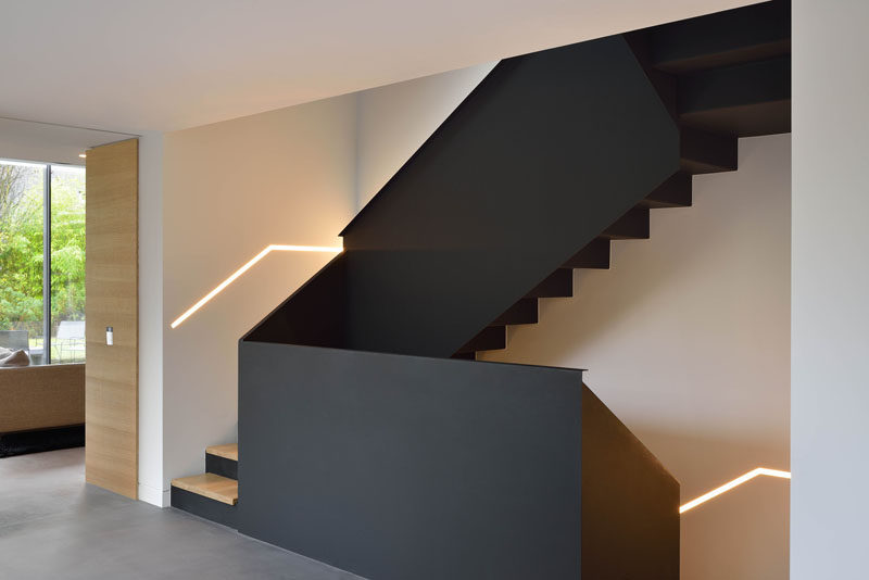 These black and wood modern stairs connect the various floors of this renovated home.