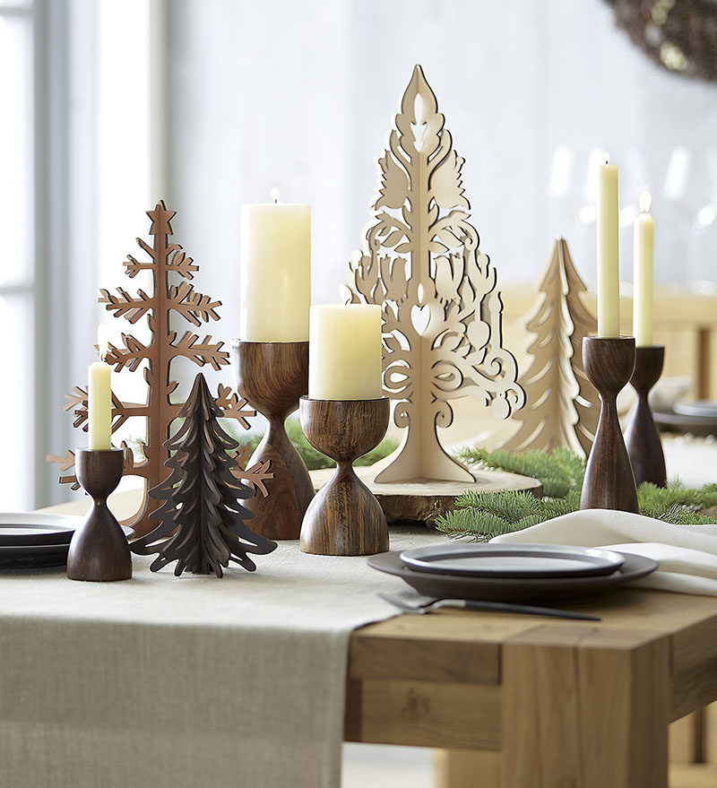 15 Inspirational Ideas For Creating A Modern Christmas Table Full Of Natural Elements // Tall wooden candle sticks mixed in with other wooden decor create a natural yet festive centerpiece you'd be likely to find in a Nordic style home.