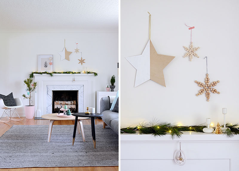30 Modern Christmas Decor Ideas For Your Home // A simple garland of natural greenery and twinkle lights and the wooden decorations above the mantle keep this bright living room feeling welcoming yet cozy.