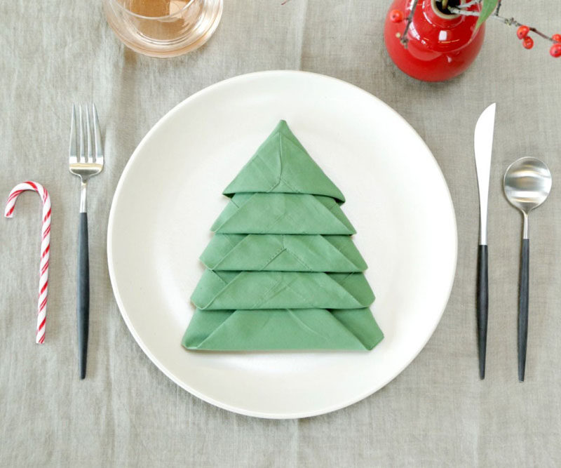 15 Inspirational Ideas For Creating A Modern Christmas Table Full Of Natural Elements // Folding your napkins into the shape of Christmas trees and including a candy cane makes for a fun place setting that grown ups and children alike will enjoy.