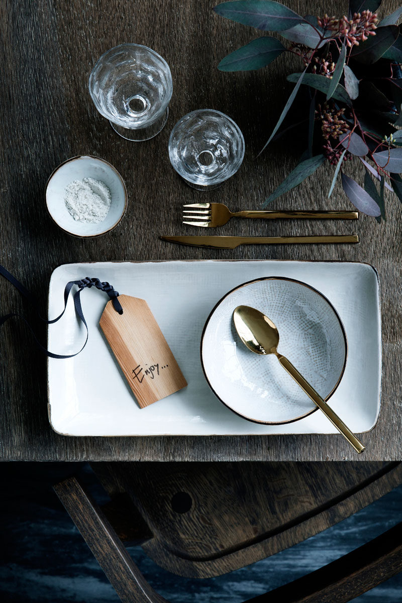 15 Inspirational Ideas For Creating A Modern Christmas Table Full Of Natural Elements // Gold cutlery make this place setting feel more unique and elegant while the wooden gift tag (that could also be used as a name tag) adds a modern, natural touch to the table.