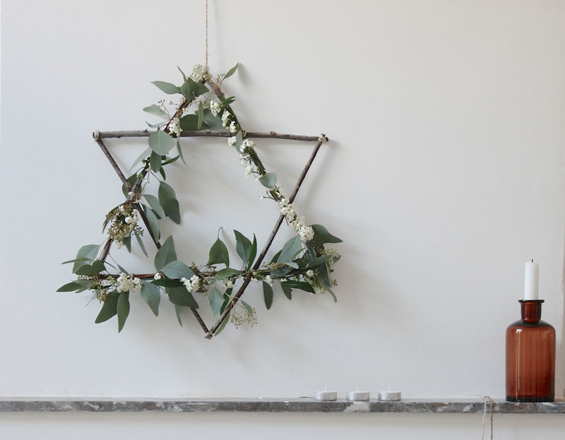 21 Modern Wreaths To Decorate Your Home With This Holiday Season // This star wreath made from twigs and natural greenery creates a Scandinavian Christmas feel and would work on any door or above any mantle.