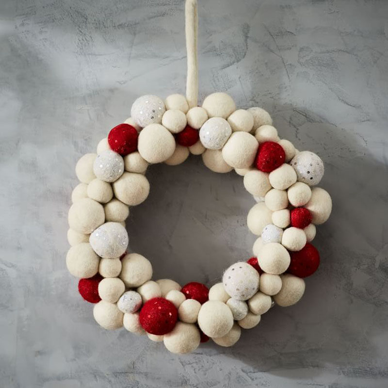 21 Modern Wreaths To Decorate Your Home With This Holiday Season // The felt balls in various holiday colors on this modern wreath make it the perfect addition to the front door.
