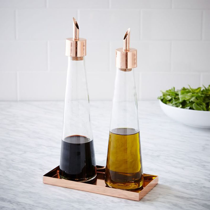 Essential Kitchen Tools - 11 Creative Oil & Vinegar Dispensers // The copper tray matches the glass and copper dispensers making for an elegant set up right next to your stove.