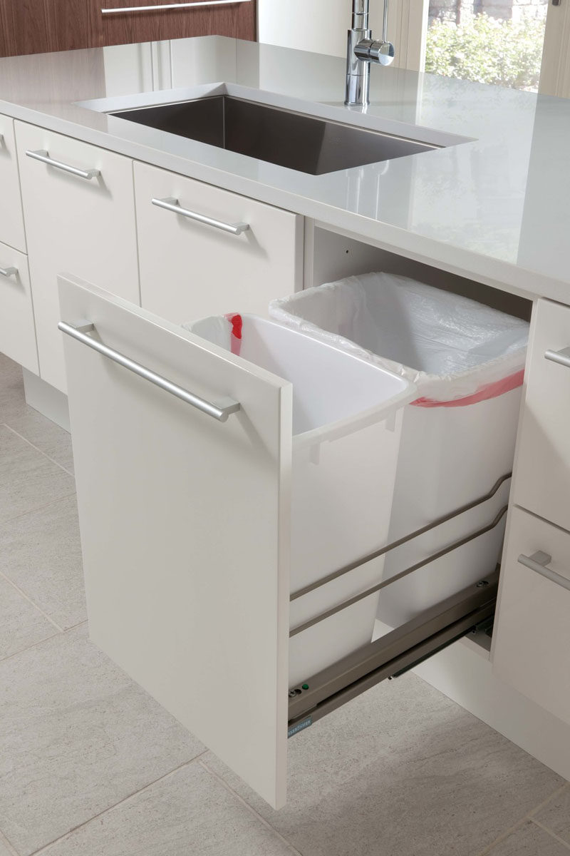 Kitchen Design Idea - Hide Pull Out Trash Bins In Your Cabinetry // These trash bins sit on the pull out shelf next to the sink where much of the food prep is done, making it easy to wipe food remnants off the counter and into the bin.