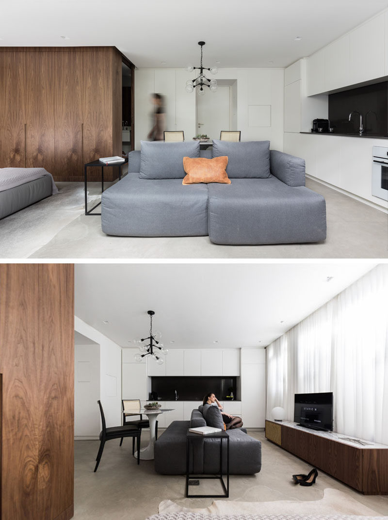 In this small apartment ,the entry, kitchen, living, dining and bedroom all share the same area. The living room had a custom sofa designed to fit the space, and a long tv cabinet provides extra storage.