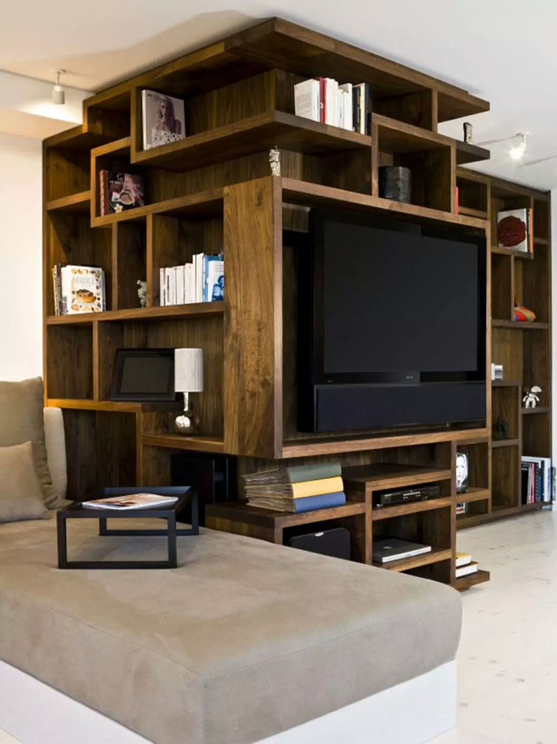 8 TV Wall Design Ideas For Your Living Room // This custom artistic shelving unit that wraps around the corner has a spot that's just the right size for the TV and sound bar to be mounted in.