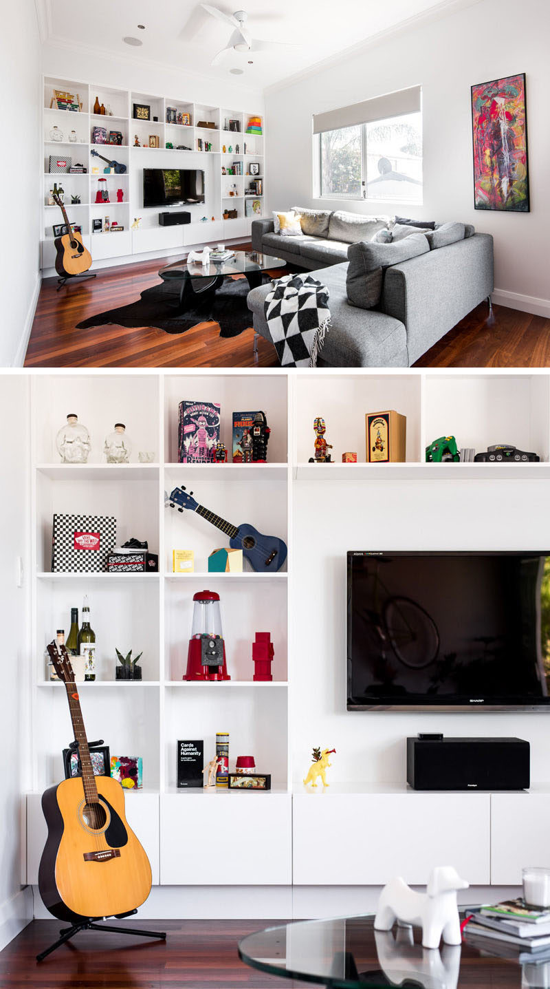 8 TV Wall Design Ideas For Your Living Room // Square shelves surround the TV and bring in pops of color to the all white shelving unit.