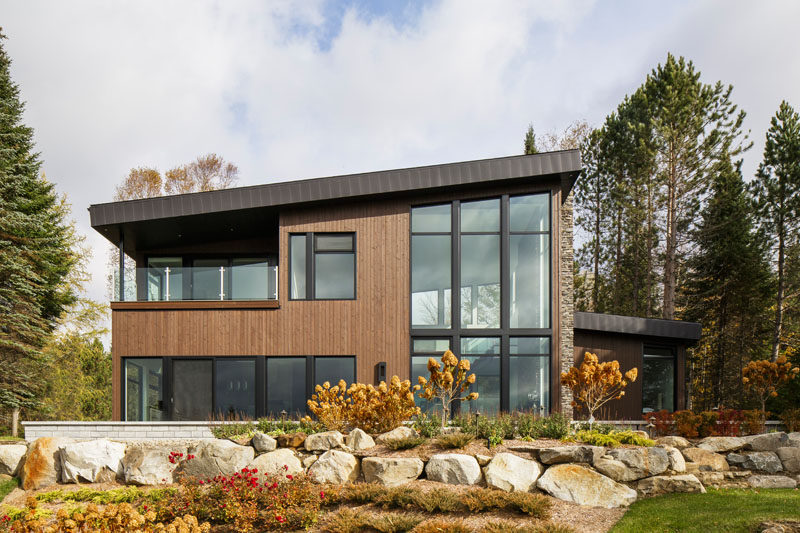 This modern lake house in Canada has an exterior clad in wood, stone, and metal
