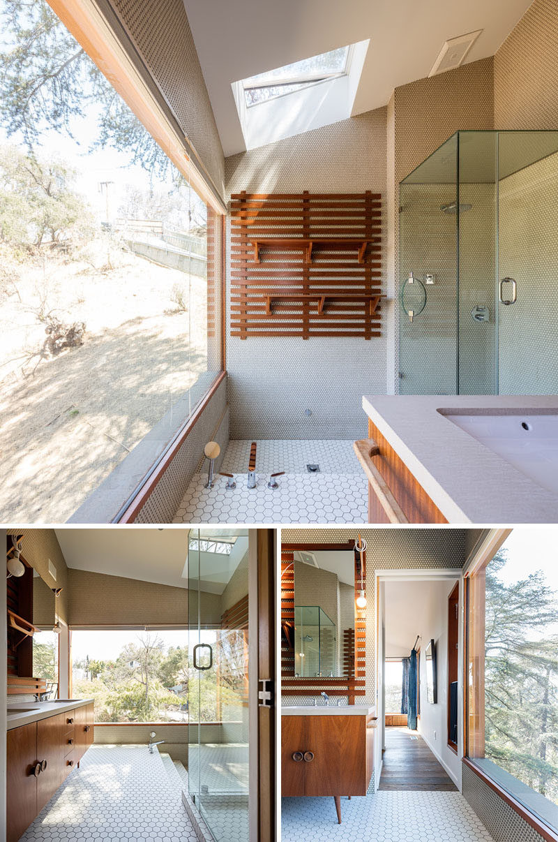 This contemporary bathroom has a skylight, a sunken bath, and views of the valley below.