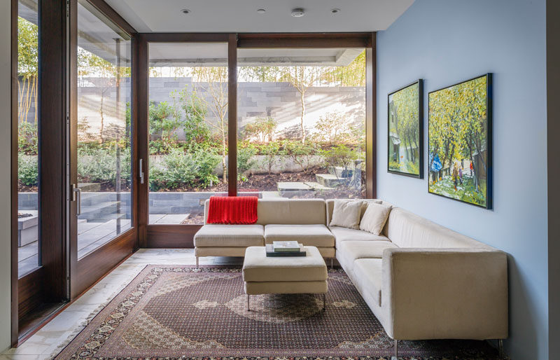 This corner living room has large sliding glass and wood doors that open up to an outdoor area.