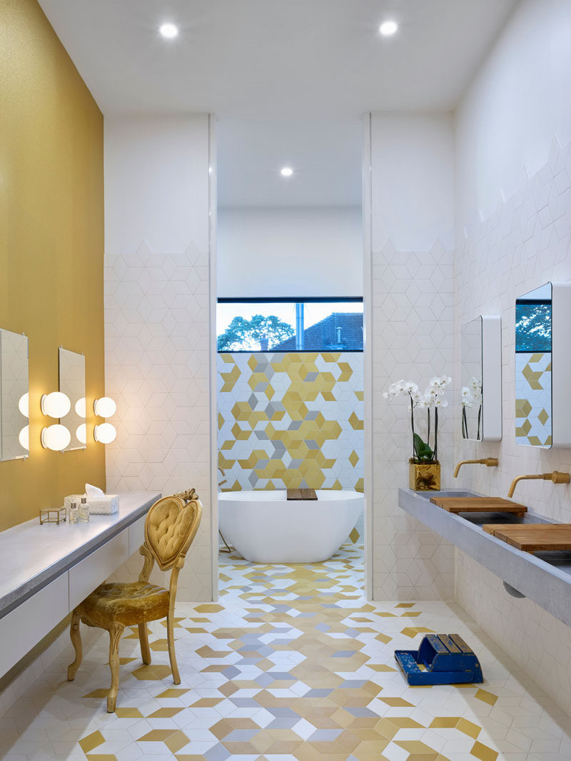This modern kids bathroom was designed for three girls, and it has three sinks, three makeup stations and fun, colorful geometric tiles. 