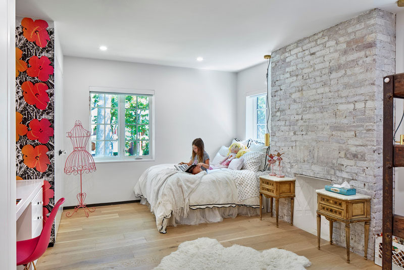 This girls bedroom in a renovated heritage house features the an original fireplace with brick surround.