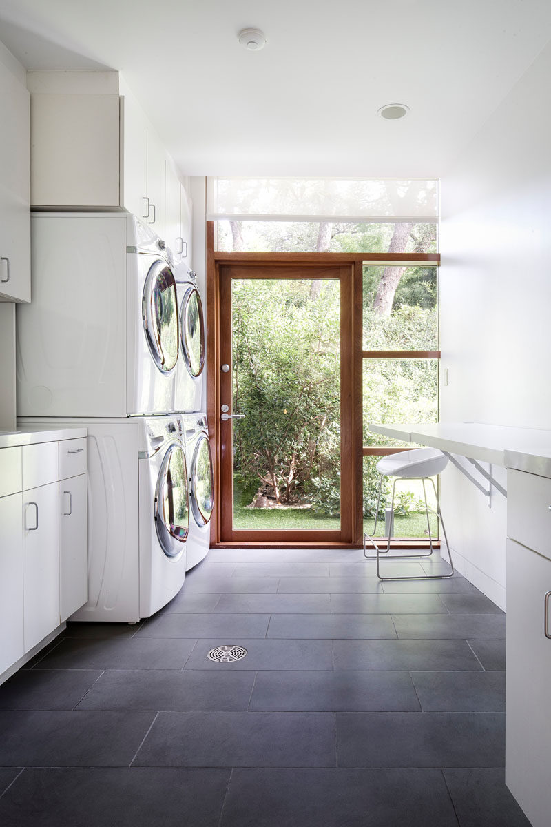 This large laundry room has double washing machines and dryers, as well as plenty of storage and folding space.