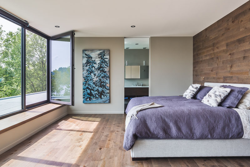 In this bedrooms there's a built-in window seat, a wooden accent wall that matches the floor, and an ensuite bathroom.