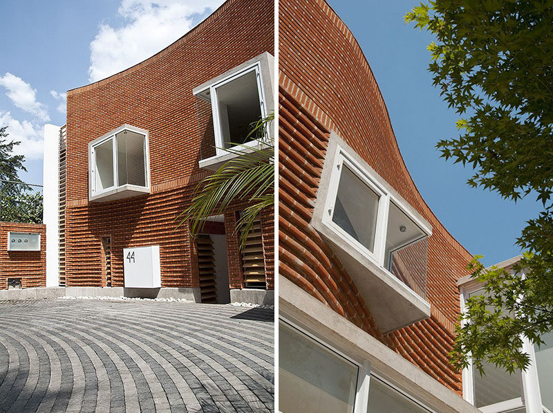 14 Modern Houses Made Of Brick // The bricks on this house have been arranged in a curved wave-like design to designate the private areas of the home. They also contrast the modern glass look of the more public areas on the first floor.