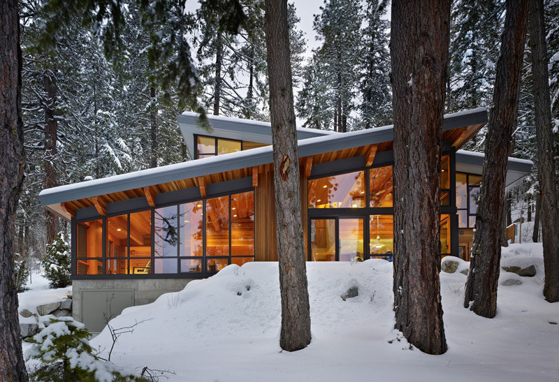 16 Examples Of Modern Houses With A Sloped Roof | This modern lake house has multiple sloped roofs to allow the rain and snow to easily slide off.