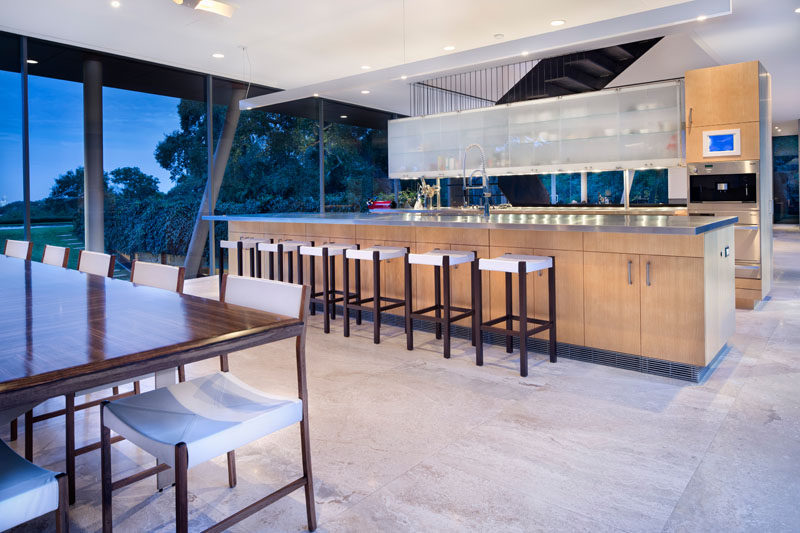 This kitchen with a long island separates the dining area from the stairs and living room.