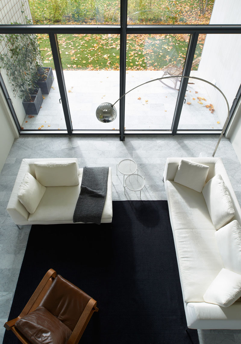Interior Design Ideas - 17 Modern Living Rooms As Seen From Above | White couches, a leather chair, and a large dark area rug give this living room a bright and open look that also feels cozy and warm.